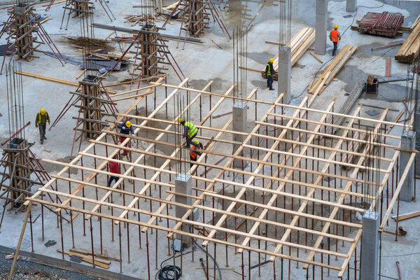 Workers on the wooden constructions at the construction site