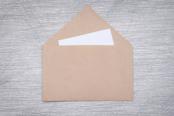 Envelope Artesanato Marrom Com Cartão Papel Branco Fundo Cinza — Fotografia de Stock