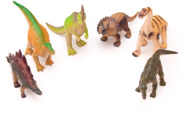 Beyaz arka planda oyuncak plastik dinozorlar grubu.