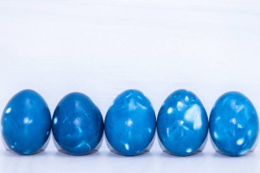 Beyaz ahşap arka planda beş mavi uzay galaktik Paskalya yumurtası. Kapatın. Paskalya tebrik kartı. Boşluğu kopyala.