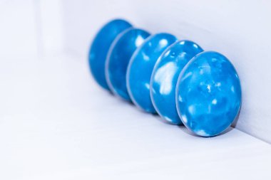 Beyaz ahşap arka planda beş mavi uzay galaktik Paskalya yumurtası. Kapatın. Paskalya tebrik kartı. Boşluğu kopyala.