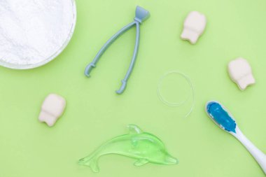 Yeşil arka planda oral bakım ürünleri olan düz kompozisyon. Diş bakımı ve sağlıklı diş konsepti.