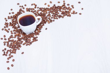 Beyaz ahşap arka planda beyaz kahve ve kahve çekirdekleri. Boşluğu kopyala, üst görünüm.