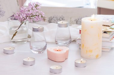 Pastel oda dekoru, yanan el yapımı mumlar, kitaplar, çiçekler. Rahat ve rahat konsept.