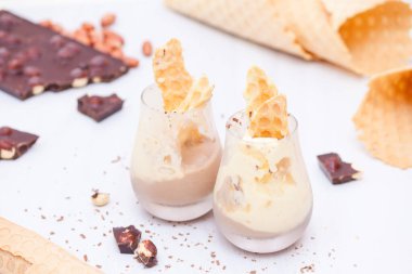 Muzlu, çikolatalı ev yapımı dondurma, beyaz ahşap arka planda fındıklı fındık..