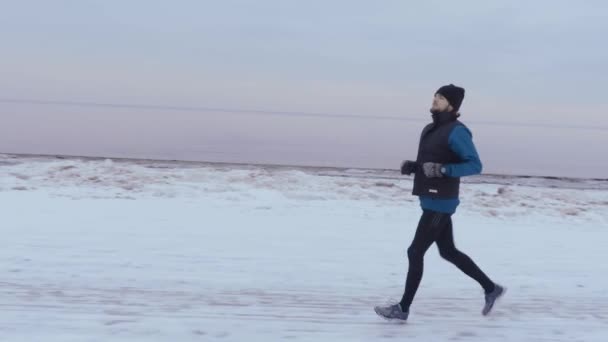 Een Man Loopt Winter Een Mooie Besneeuwde Strand — Stockvideo