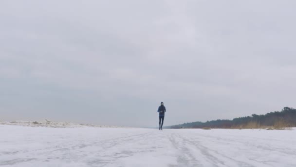 Een Man Loopt Winter Een Mooie Besneeuwde Strand — Stockvideo