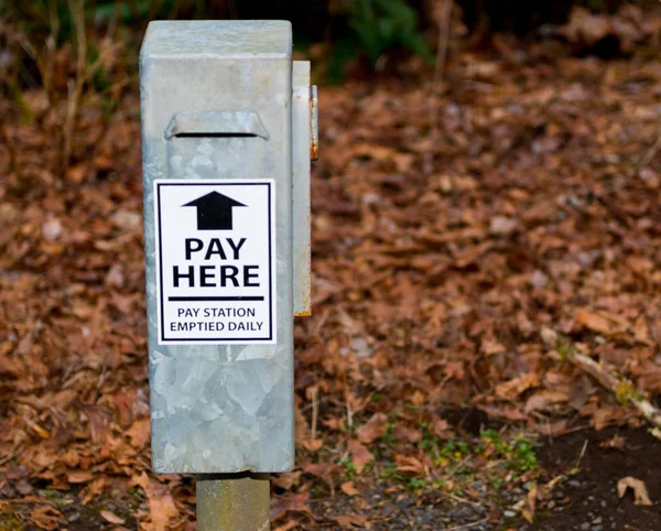 Parku mzdy stanice drop box s trávou a hnědé listy — Stock fotografie