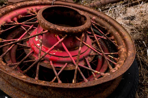 Vintage antique automotive wire wheel spokes and hub with red peeling paint and rust — Stock Photo, Image