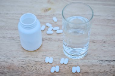 Ateş azaltmak için parasetamol masanın üzerine yerleştirilir ve bir bardak su kullanılabilir parasetamol su ile