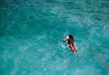 Güzel sörfçü kız dışarı Uluwatu beach, Bali, Endonezya, Hint Okyanusu'nun berrak mavi suda kürek çekmeye uygun. Kopya alanı