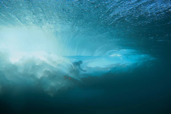 Surfer surfing tube section of the wave in crystal clear water in Mentawai island, Indonesia