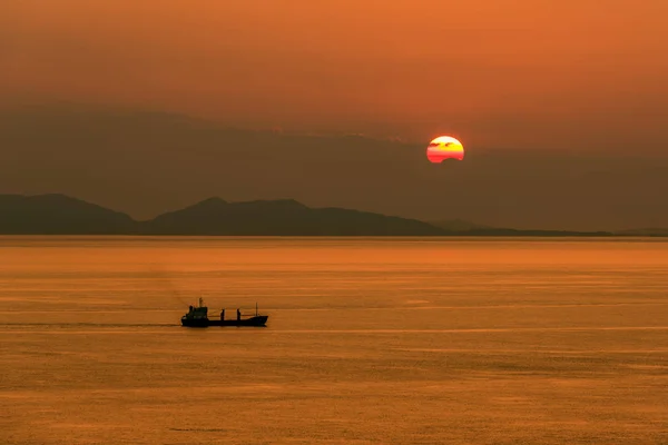 Ship passing the setting sun