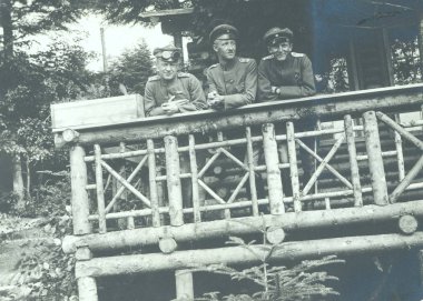 Beton sığınak içinde duran ve kameraya poz üç subay