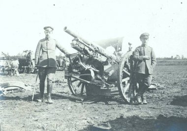 Two german soldiers posing in front of damaged and captured field gun clipart