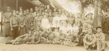 platoon of russian soldiers posing with red cross sisters in front of tent clipart