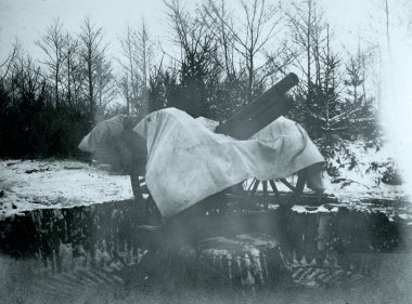 camouflaged field gun modified for AA use on emplacement clipart
