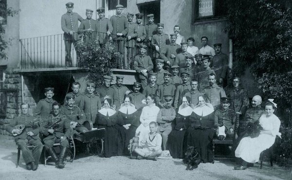 солдаты и монахини позируют перед камерой перед полевым госпиталем

