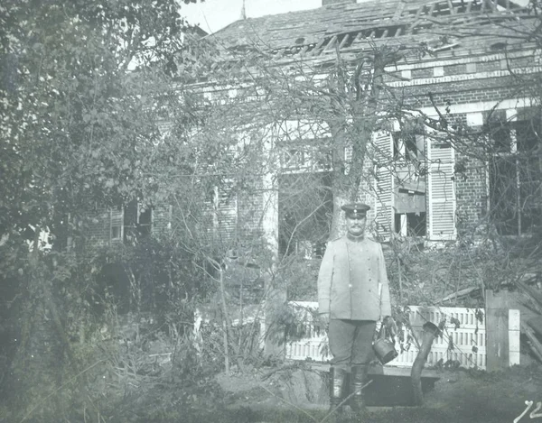 德国中士站在损坏的房子前面 — 图库照片