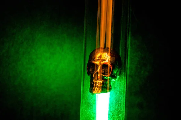 Cráneo de metal colocado en frasco e iluminado por luz verde en Da — Foto de Stock