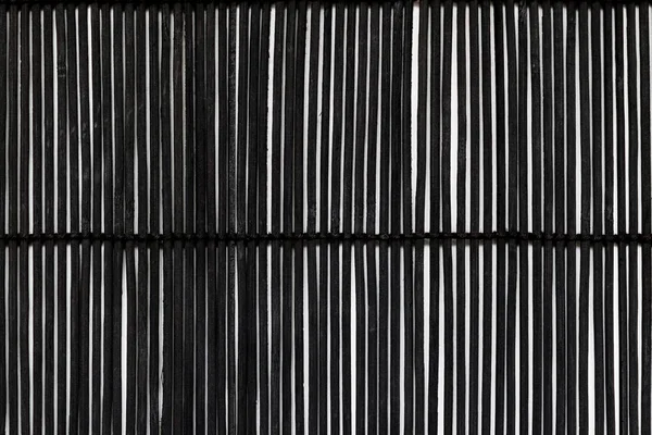 Černé bambusové rohože na bílém pozadí svázaný s lanem — Stock fotografie