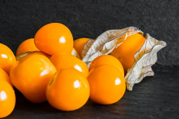 Cape Gooseberries em fundo de superfície Black Rock — Fotografia de Stock