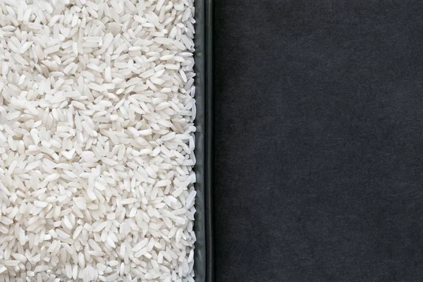 Зерна риса в пластине и черный фон с свободным пространством — стоковое фото