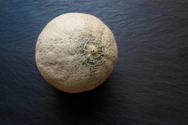 Hami kavun meyve siyah taş üzerinde arka plan boş alan ile yüzey