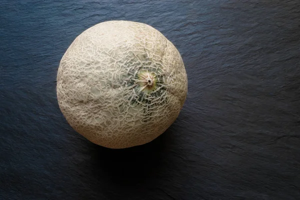 Hami Melon Fruit em fundo de superfície de pedra preta com espaço livre — Fotografia de Stock