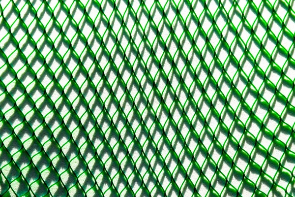 Grünes Netz wirft den Schatten auf den weißen Hintergrund — Stockfoto
