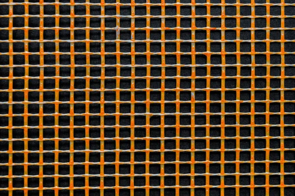 Orange plast rutnät på svart bakgrund yta — Stockfoto