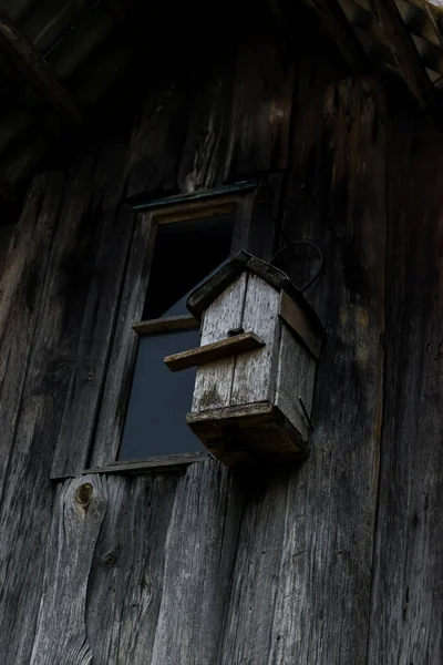 Scatola di nidificazione grigia molto vecchia appesa alla parete del fienile grigio in legno — Foto Stock