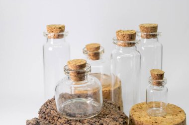 Beyaz arka planda mantar kapaklı cam şişeler