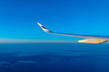 Finlandiya Helsinki 2 MAR 2020 Mavi Finnair havayolları logosu mavi gökyüzü ve mavi dünya ufkunun önünde gün batımında