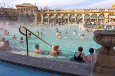 Budapeşte, Macaristan - 02/19/2018: termal hamam Szchenyi rahatlatıcı ile açık hava güneşli günde insanlar. Ünlü Macar spa Hamam. Sakin ol ve eğlence kavramı. Sıcak termal yüzme havuzu üzerinde buhar.