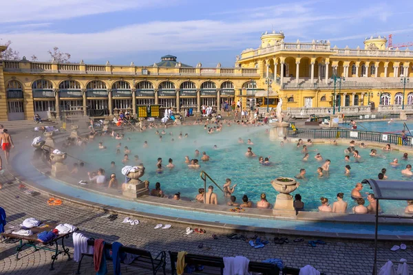 Budapeşte, Macaristan - 02/19/2018: termal hamam Szchenyi rahatlatıcı ile açık hava güneşli günde insanlar. Ünlü Macar spa Hamam. Sakin ol ve eğlence kavramı. Sıcak termal yüzme havuzu üzerinde buhar.