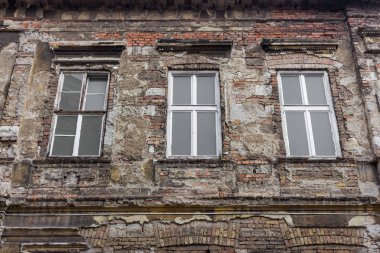 Üç pencereli terk edilmiş eski bir bina. Yaşlı tuğla duvar. Vintage mimari konsepti. Eski bir ev. Isınma arka planı. Grunge tasarım mimarisi.