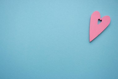 Pembe ahşap kalp tebrik kartı köşesinde kopya alanı ile azure arka plan üzerinde. İzole kalp şekli. Vintage love tasarım. Aşk ve romantizm kavramı. Sevgililer günü. Tutku kavramı.