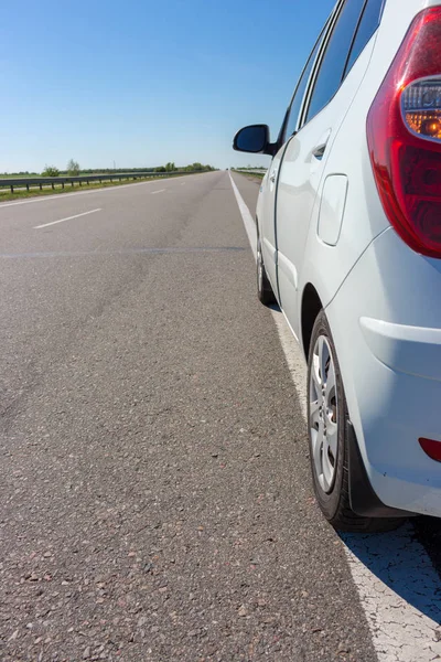 White car on beautiful empty highway. Transport concept. Speed and motion background. Summer landscape with white car. Summer travel concept. Adventure time concept. Car with road in perspective view.