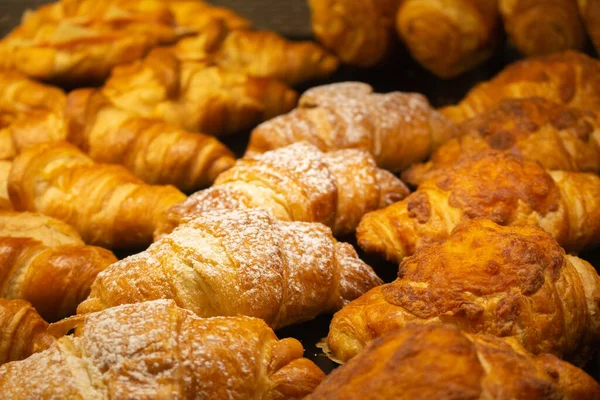 美味的羊角面包陈列在橱窗里 金黄色的面包店 新鲜的烤法国蛋糕 糕点特写 美味的早餐 早上在咖啡店烘焙 自制炊具 — 图库照片