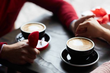 Çift el ele tutuşarak, kahve içme ve hediyeler caf adlı paylaşım aşık. adam bir teklif yapıyor. Sevgililer günü kavramı