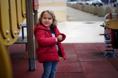 Küçük kız oyun alanında oynuyor.