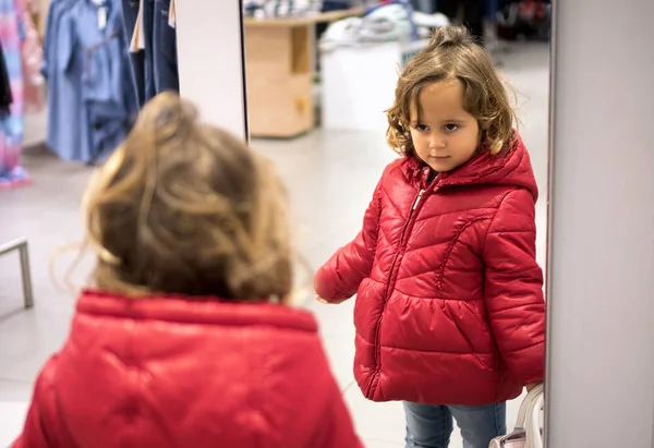 Девочка смотрит в зеркало в магазине — стоковое фото