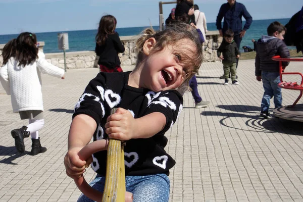 Little girl plays happy in a playground