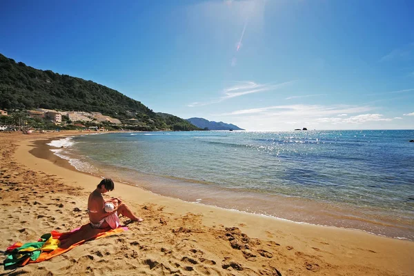 Mother breastfeeding a child on the beach — Stock Photo, Image