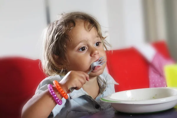 Petite fille mange avec une fourchette — Photo