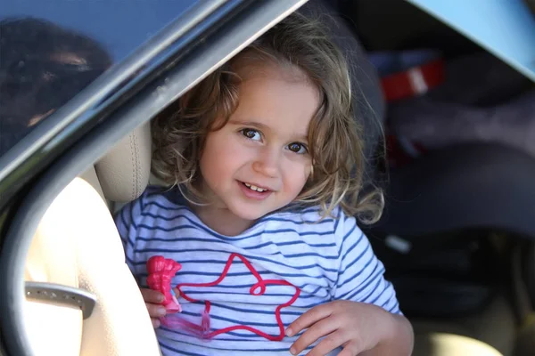 La niña mira hacia fuera del coche — Foto de Stock