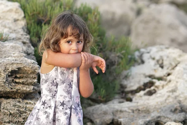 Little girl on the background of Mediterranean rocks — Stock Photo, Image