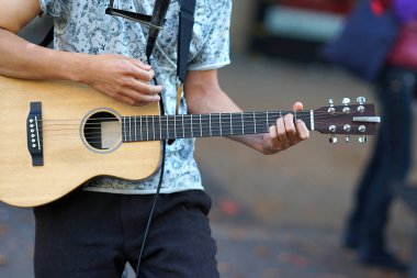Bir müzisyen gitar çalar, ellerin detaylarını.