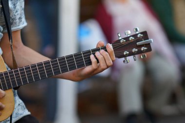 Bir müzisyen gitar çalar, ellerin detaylarını.